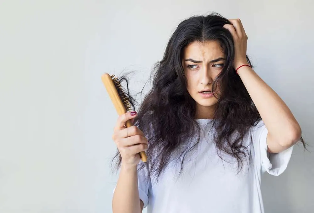 Especialista médico evaluando caída de cabello relacionada con estrés